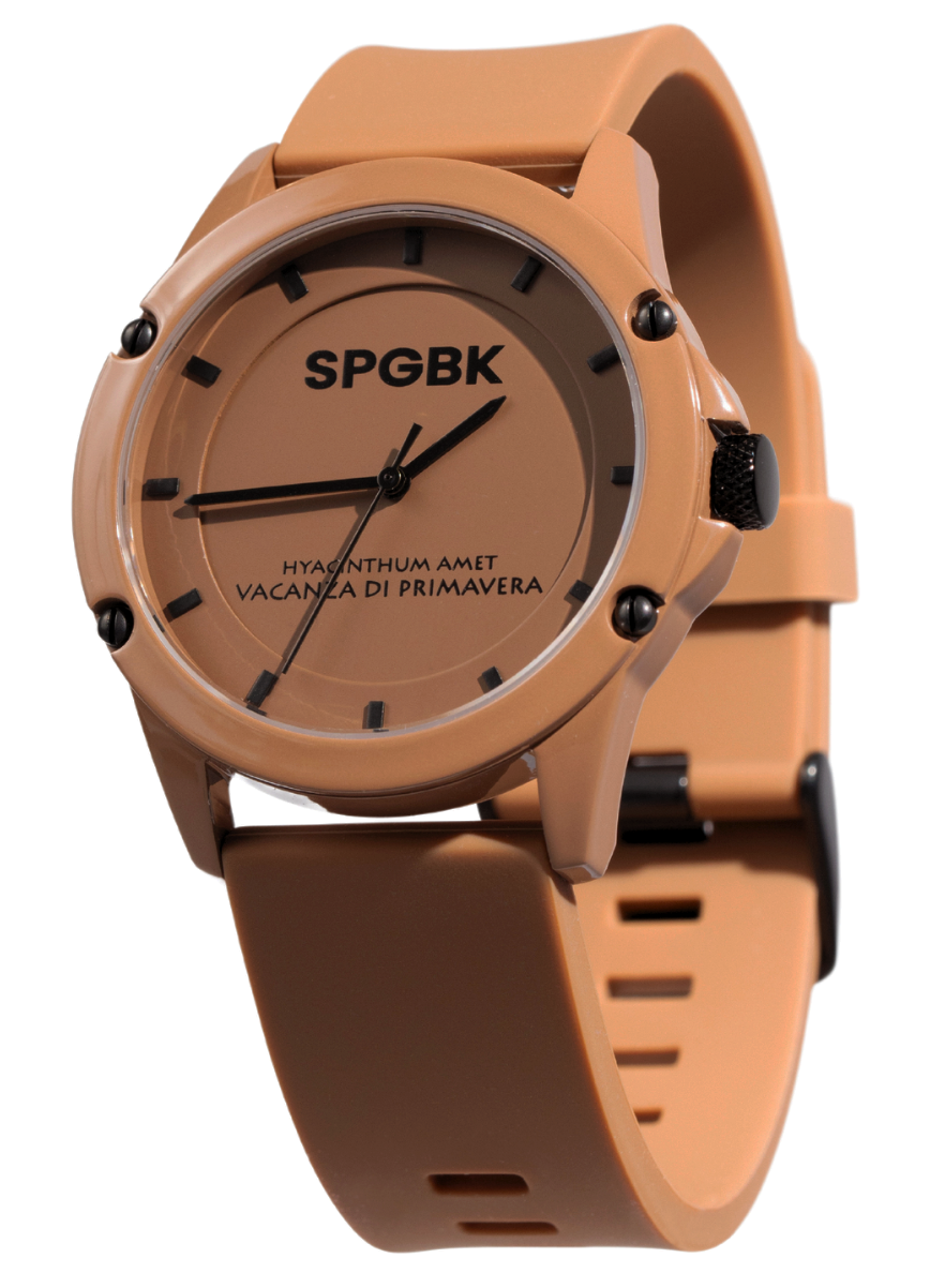 A chocolate-colored analog watch with a silicone strap and a stainless steel case, featuring the SPGBK logo on the dial.
